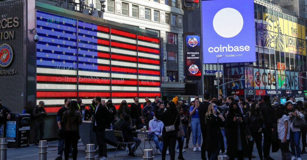 Employees of Coinbase Global Inc, the biggest U.S. cryptocurrency exchange, watch as their listing is displayed on the Nasdaq MarketSite jumbotron at Times Square in New York, U.S., April 14, 2021. REUTERS/Shannon Stapleton/File Photo