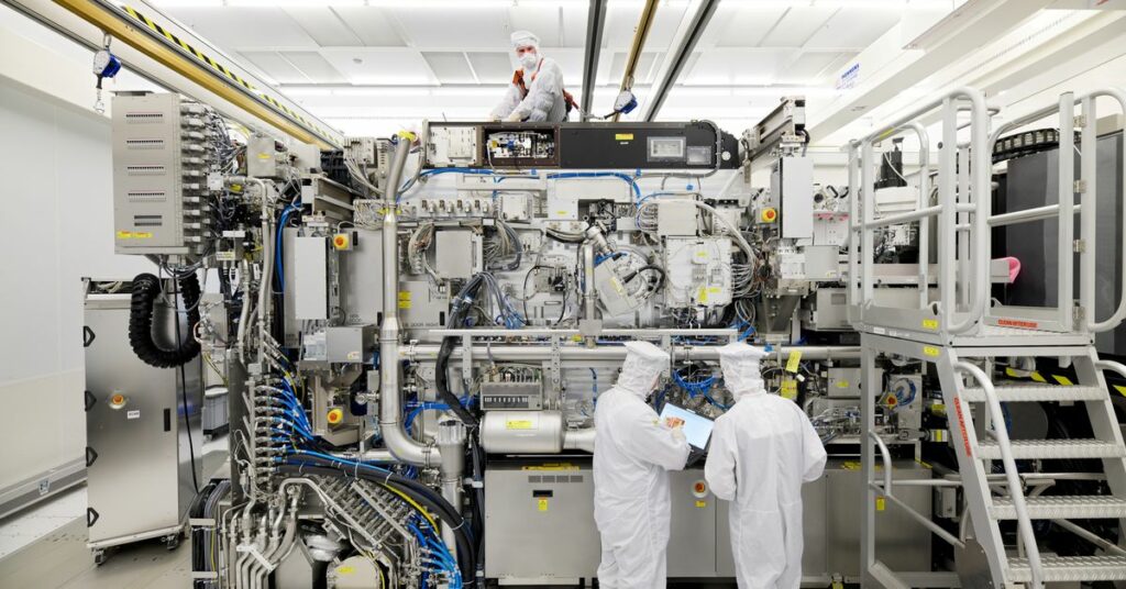 Employees are seen working on the final assembly of ASML