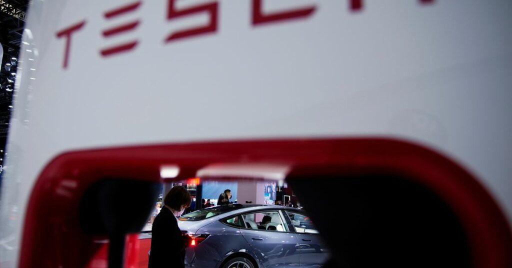 A Tesla electric vehicle (EV) is seen through a charging point displayed during a media day for the Auto Shanghai show in Shanghai, China April 20, 2021. REUTERS/Aly Song