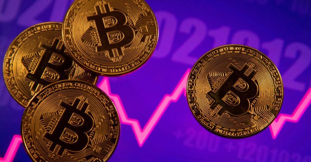 A representation of virtual currency Bitcoin is seen in front of a stock graph in this illustration taken March 15, 2021. REUTERS/Dado Ruvic/Illustration