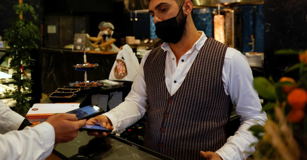 A customer makes a payment for a kebab at a restaurant that accepts Bitcoin and Dexchain in Istanbul, Turkey, April 27, 2021. Picture taken April 27, 2021. REUTERS/Umit Bektas