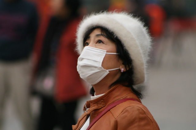 Una mujer china con una máscara.