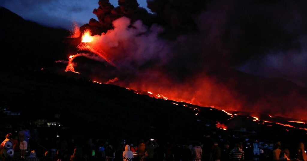 A cross is seen as the Cumbre Vieja volcano continues to erupt in the background at Los Llanos de Aridane, on the Canary Island of La Palma, Spain, October 23, 2021. REUTERS/Susana Vera