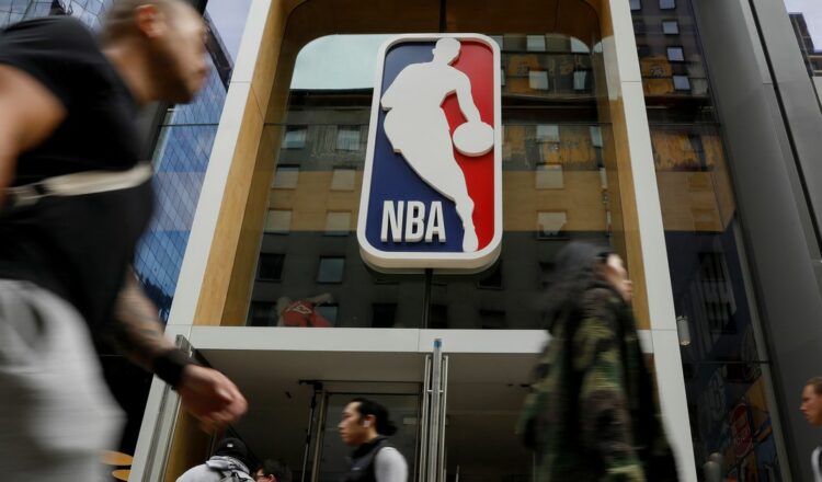 The NBA logo is displayed as people pass by the NBA Store in New York City, U.S., October 7, 2019. REUTERS/Brendan McDermid