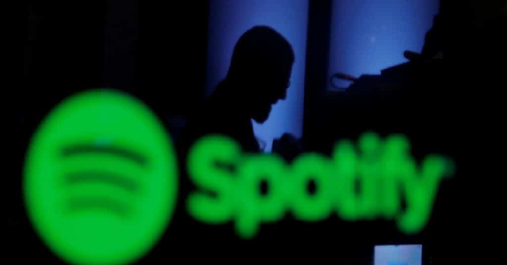 A trader is reflected in a computer screen displaying the Spotify brand before the company begins selling as a direct listing on the floor of the New York Stock Exchange in New York, U.S., April 3, 2018.  REUTERS/Lucas Jackson