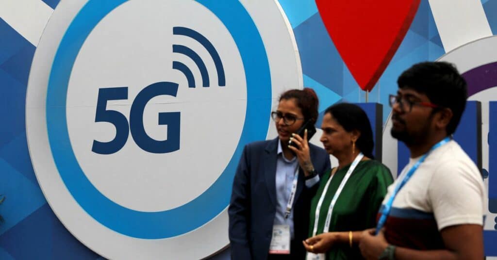 People stand in front of a board depicting 5G network at the India Mobile Congress 2018 in New Delhi, India, October 26, 2018. REUTERS/Anushree Fadnavis
