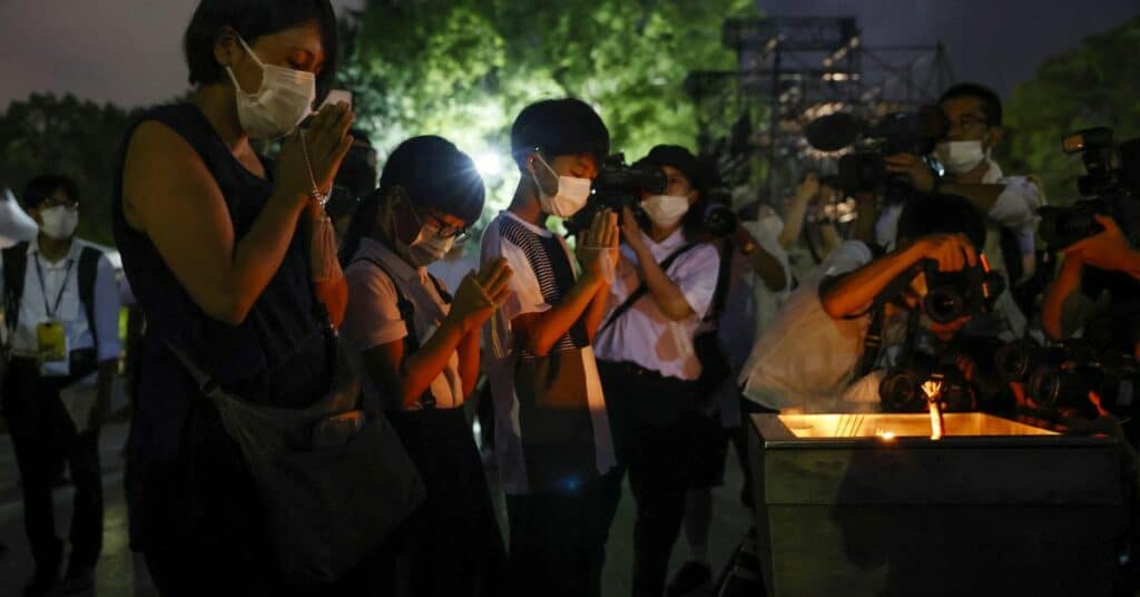 FILE PHOTO - People pray in front of the cenotaph for the victims of the 1945 atomic bombing, at Peace Memorial Park in Hiroshima
