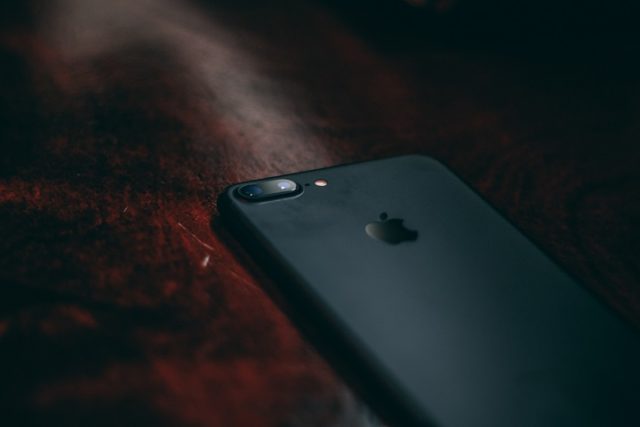 Un iPhone negro en la esquina de una mesa.