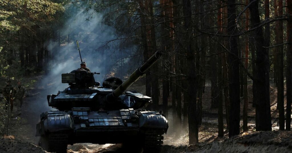 Ukrainian soldiers re-fit captured Russian tanks, in Kupiansk region