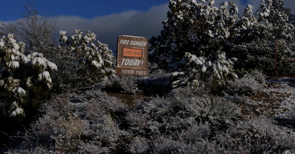 Fresh snow is shown on a fire danger sign near the side of a mountain highway near Taylor, California