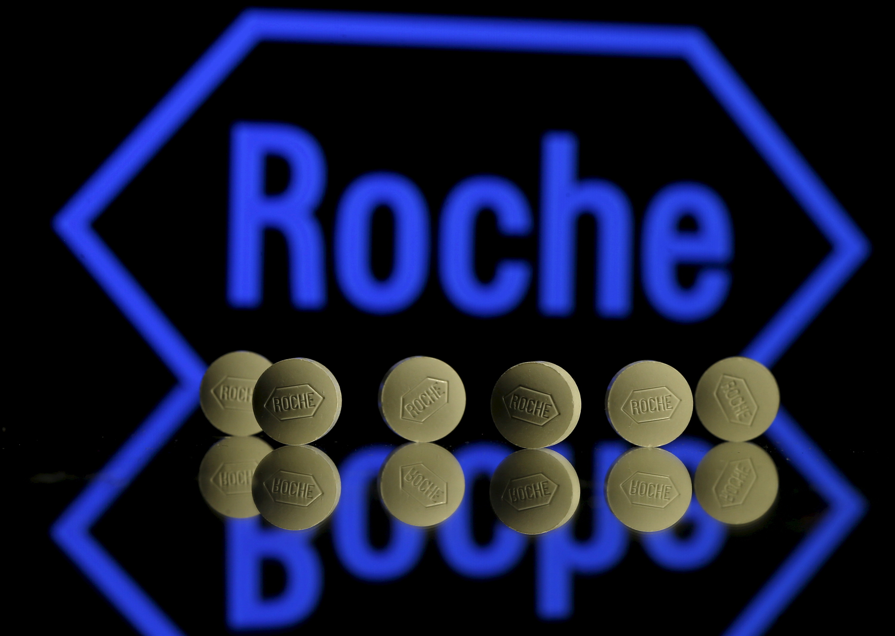 En esta ilustración fotográfica se ven comprimidos de Roche colocados delante del logotipo de Roche.